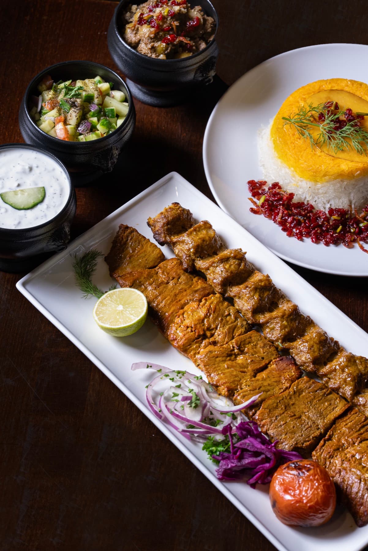 Soltani platter with barg and koobideh, saffron tahdig, and salads
