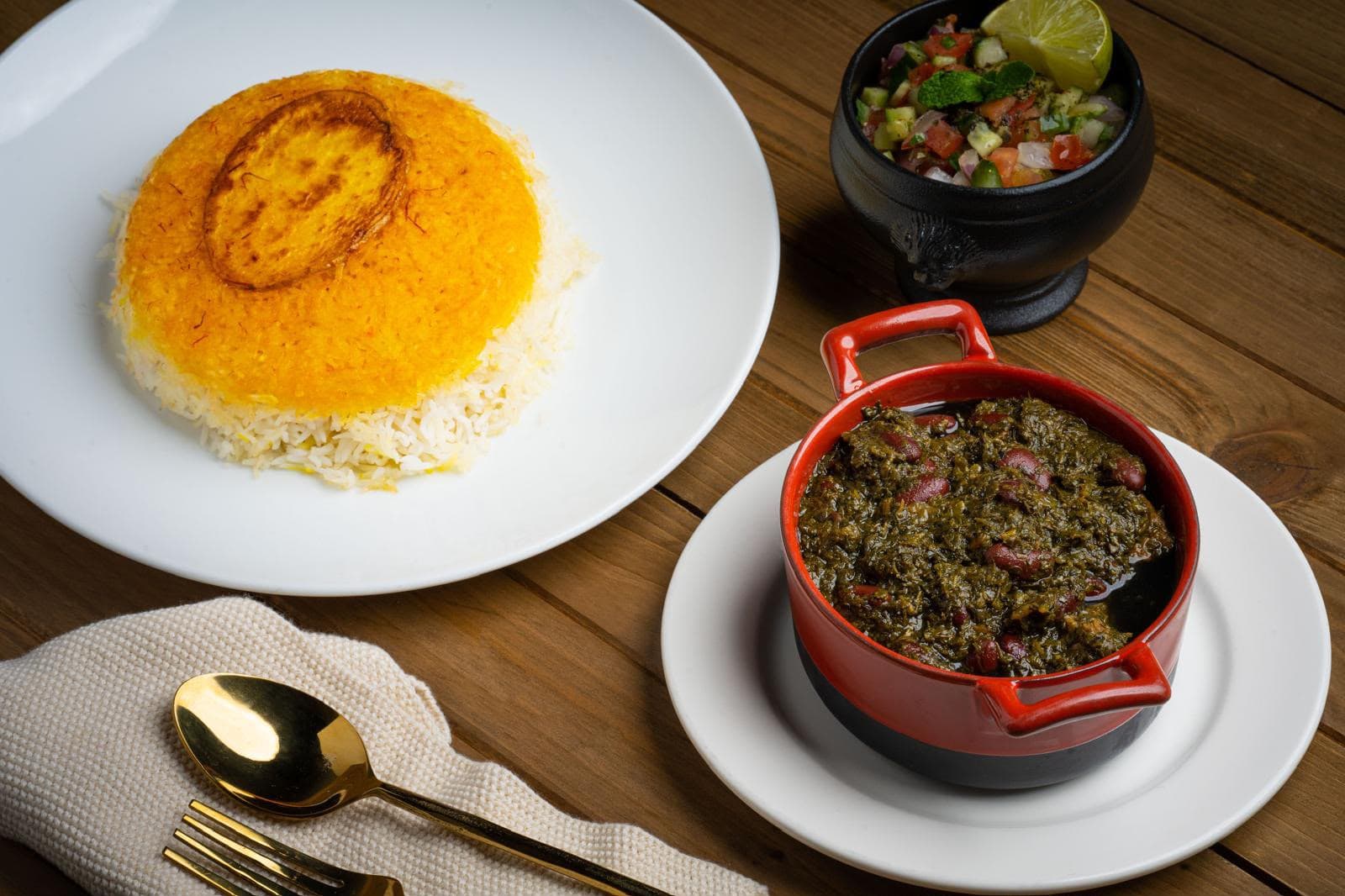 Saffron tahdig with ghormeh sabzi stew in a red pot